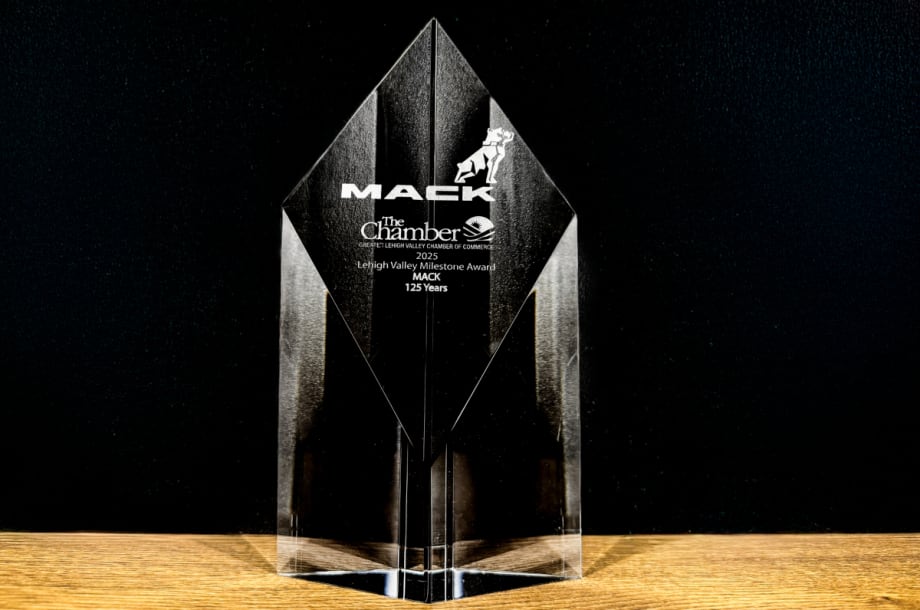 Photo of a glass looking clear award with name Mack Trucks set against a black background.