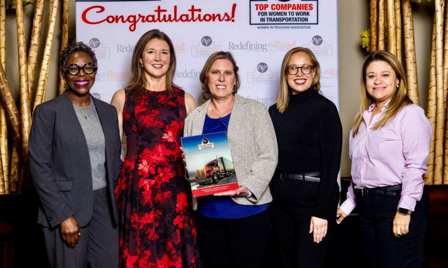 Five Peterbilt representatives pose with an award plaque after the company was named a 2025 Top Company for Women to Work in Transportation by the Women In Trucking Association.