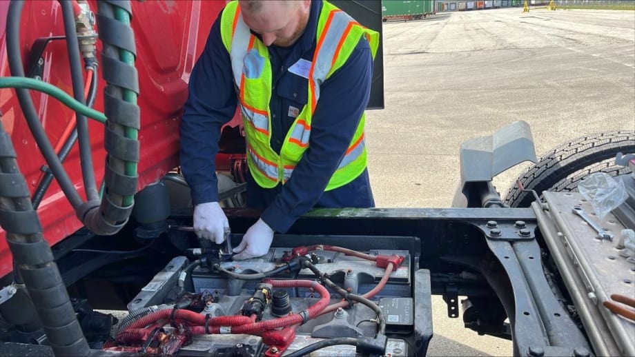 Truck technician installing Clarios' IdleLess battery monitoring system