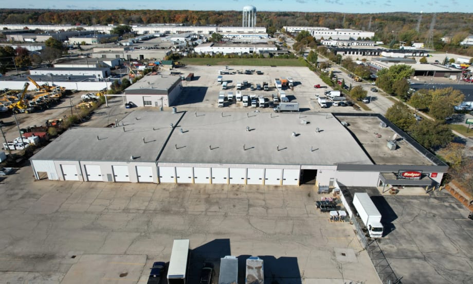 aerial view of an industrial looking large building with large parking areas.
