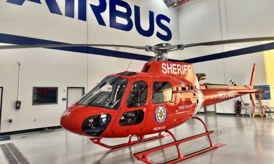 A newly delivered red Airbus H125 helicopter marked “Sheriff” and “Erie County” inside an Airbus facility.