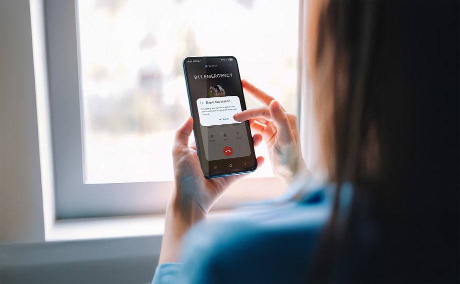 over shoulder view of woman holding phone and making an emergency call and sharing video