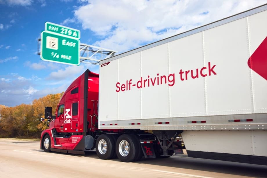 Red Kodiak autonomous truck pulling trailer that says "self-driving truck"