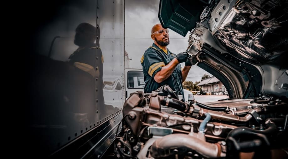 Truck technician working with hood open