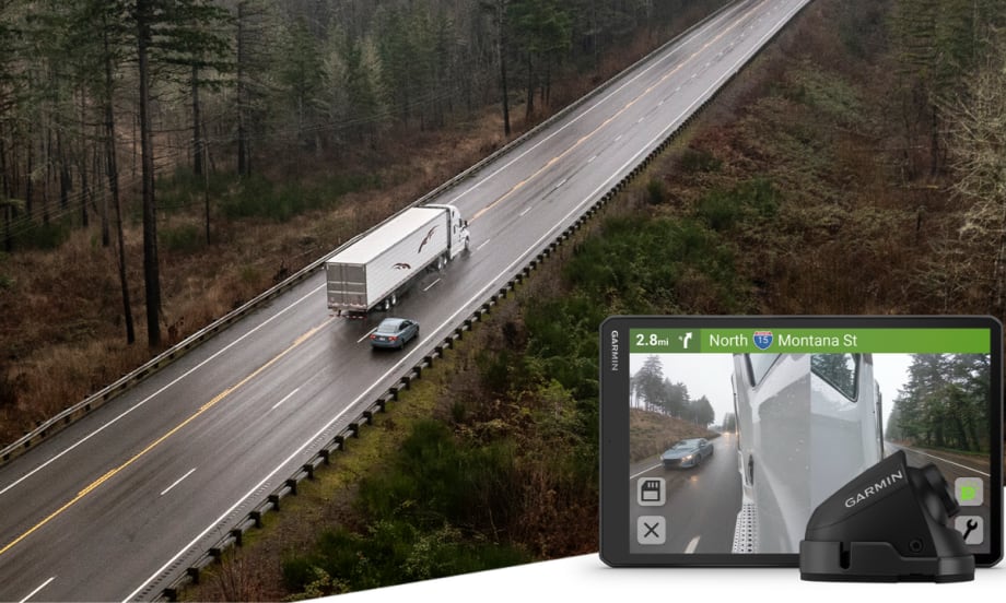 An overhead view of a tractor-trailer traveling on a two-lane highway, with an inset showing a Garmin in-cab display and side-mounted camera view of a passing vehicle.