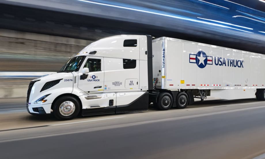 USA Truck branded tractor-trailer on road with blurred background effect
