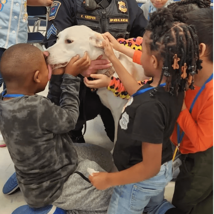 kids surround and pet a dog