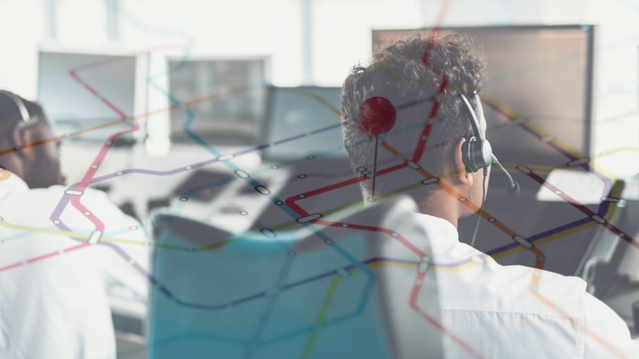 Dispatchers monitoring screens with route map overlay representing fleet telematics combined with human reporting for disaster response coordination