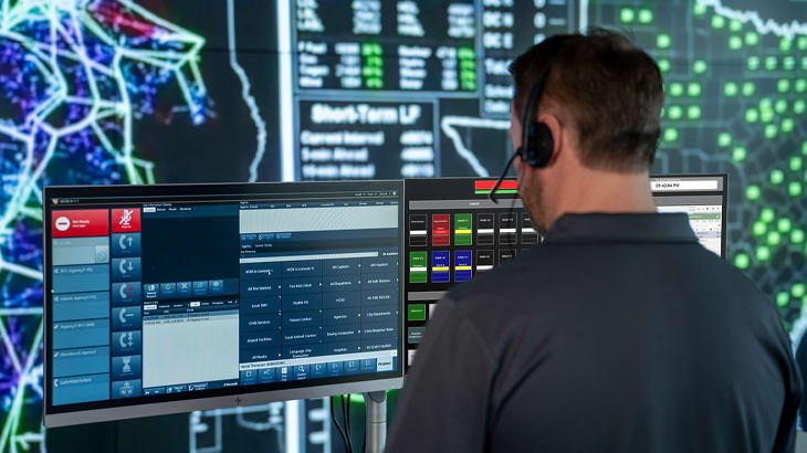 Man working in front of multiple computer screens.
