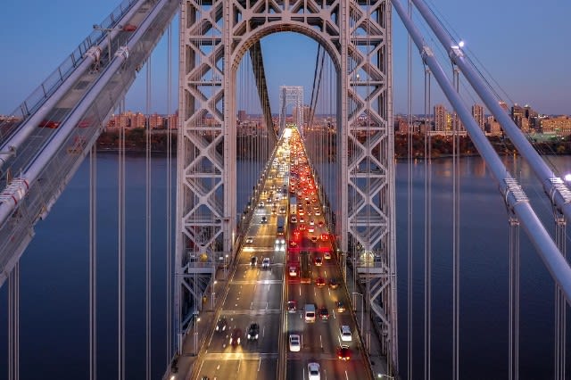 High-angle view of cars with lights turned on crossing the George Washington Bridge at dusk.