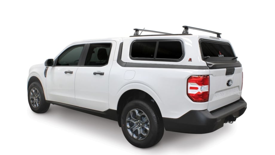 White Ford Maverick pickup equipped with a LEER truck cap and roof rack, shown from the rear three-quarter view, highlighting an integrated cargo solution for fleet, commercial, and utility applications.
