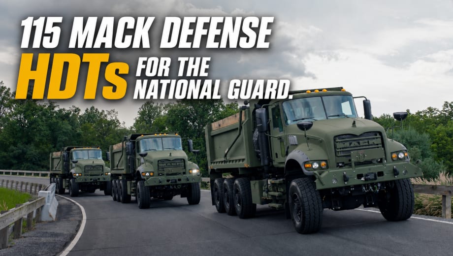 Three olive-drab Mack Defense heavy-duty tactical dump trucks drive in convoy on a roadway beneath cloudy skies, promoting delivery of 115 HDTs for the U.S. National Guard.