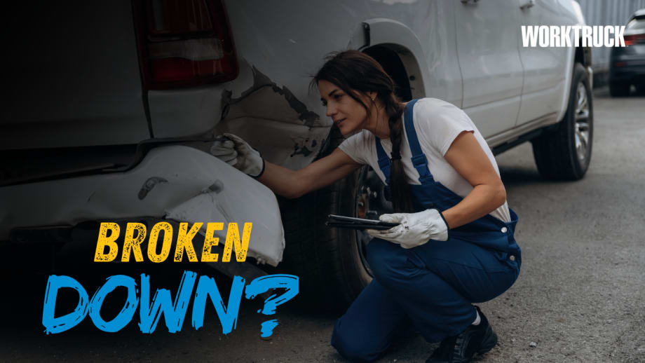 Fleet technician inspects damage to the rear quarter panel and bumper of a white work pickup. The graphic reads “Broken Down?” with the Work Truck logo.
