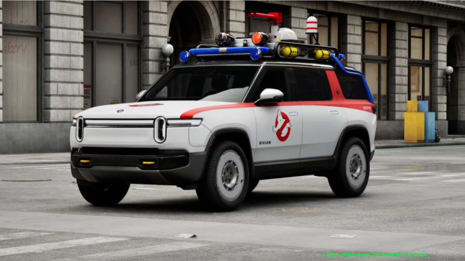 White Rivian R1S SUV customized as the Ghostbusters Ecto-R1, featuring the Ghostbusters logo, red accents, roof-mounted equipment, and emergency-style lights.