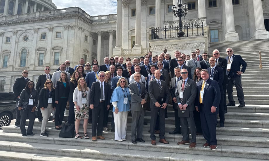 a large group of people stand together on the steps of the U.S. Capitol building