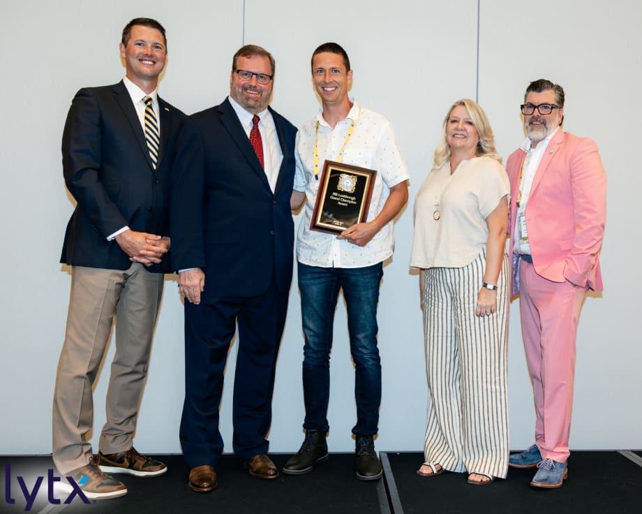Brian Rickmann poses with event presenters and organizers during an awards ceremony recognizing excellence in school transportation.
