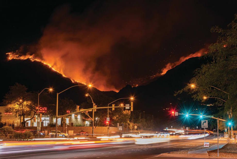 An empty street with a background of a wild fire mountain
