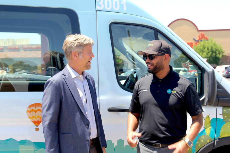 Mayor Tim Keller in front of an ABQ RIDE microtransit vehicle