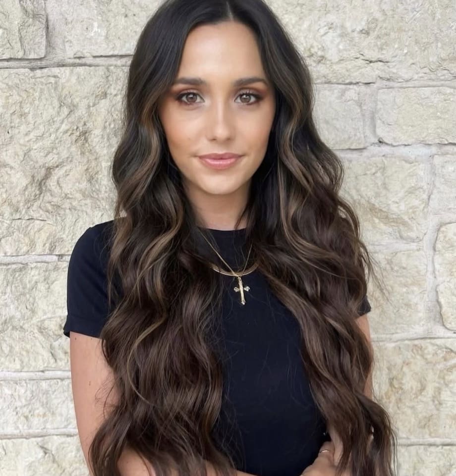 A woman with long brunette hair.