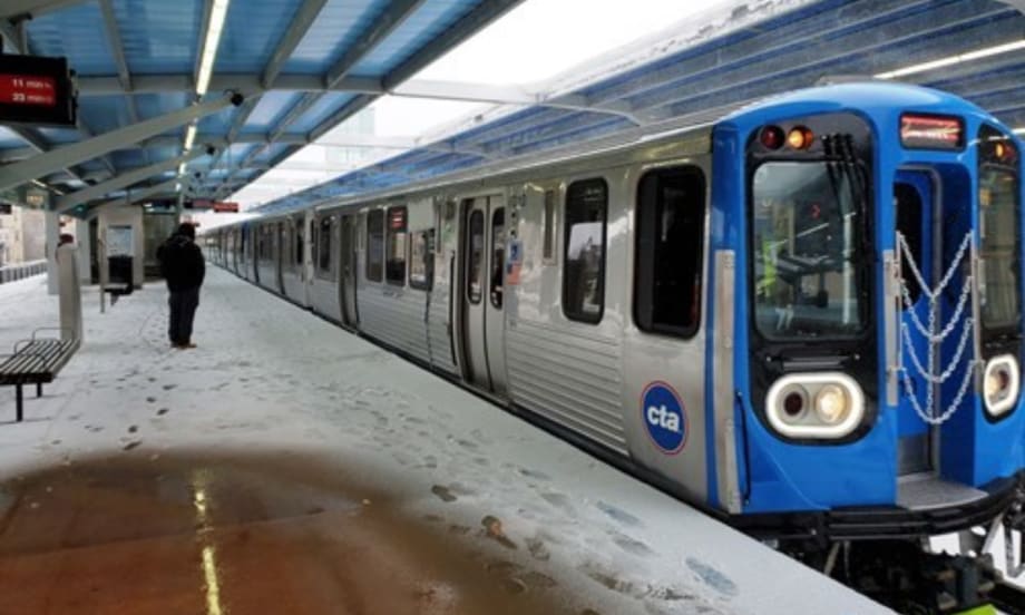 A Chicago Transit Authority 7000-series railcar at a snowy station.