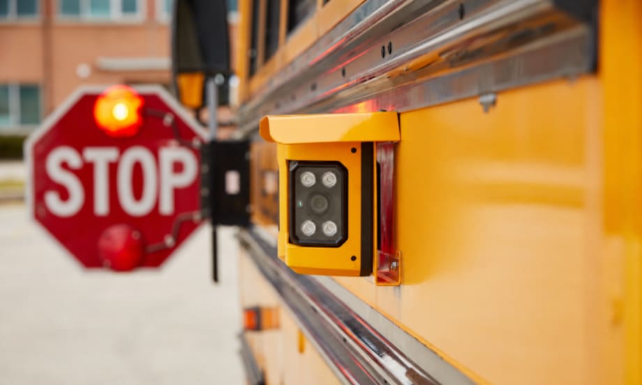 A Gatekeeper Systems camera mounted on the side of a school bus.