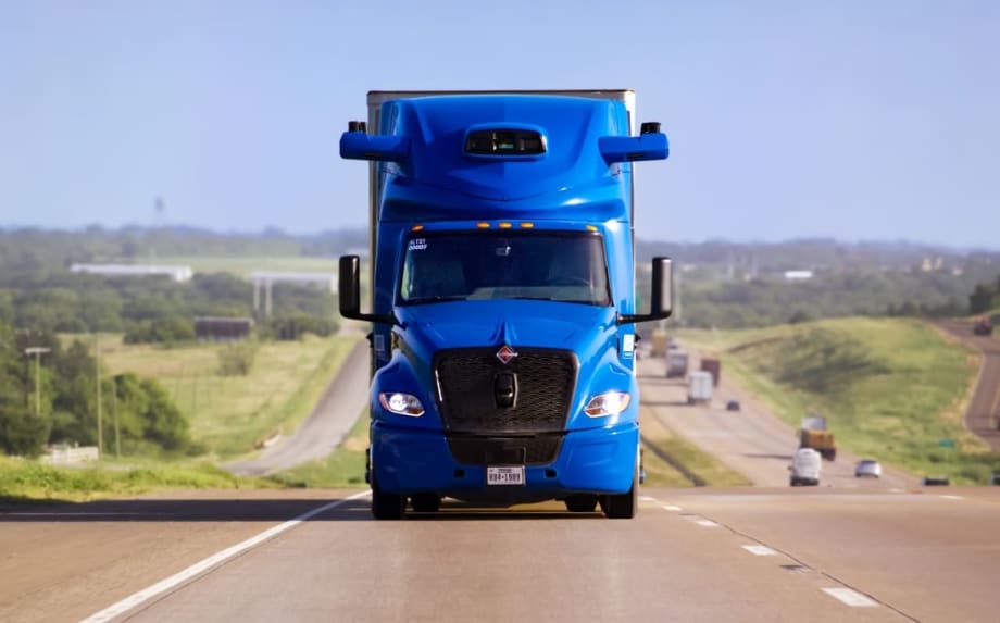 Blue International heavy-duty truck with Aurora driverless truck software coming head-on on an interstate highway