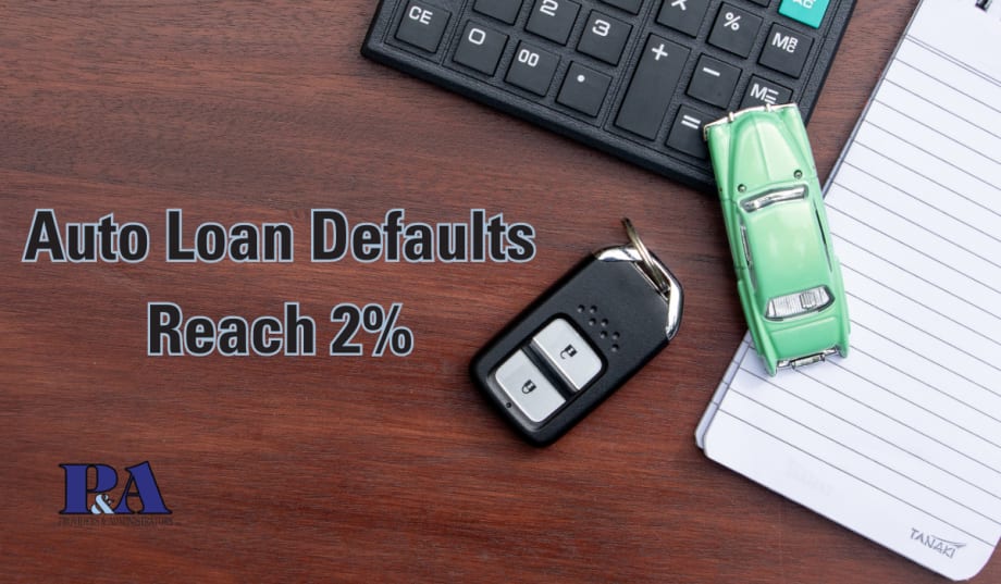 text reading Auto Loan Defaults Reach 2% on desk background with car keys, calculator, notepad, and toy car