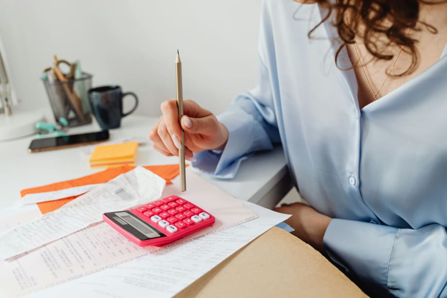 Photo of woman at desk using a calculator