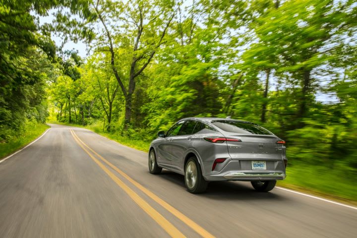 Photo of Buick Envista moving down road flanked by trees