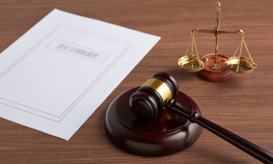 on a desk, a piece of paper, a gavel, and the scales of justice