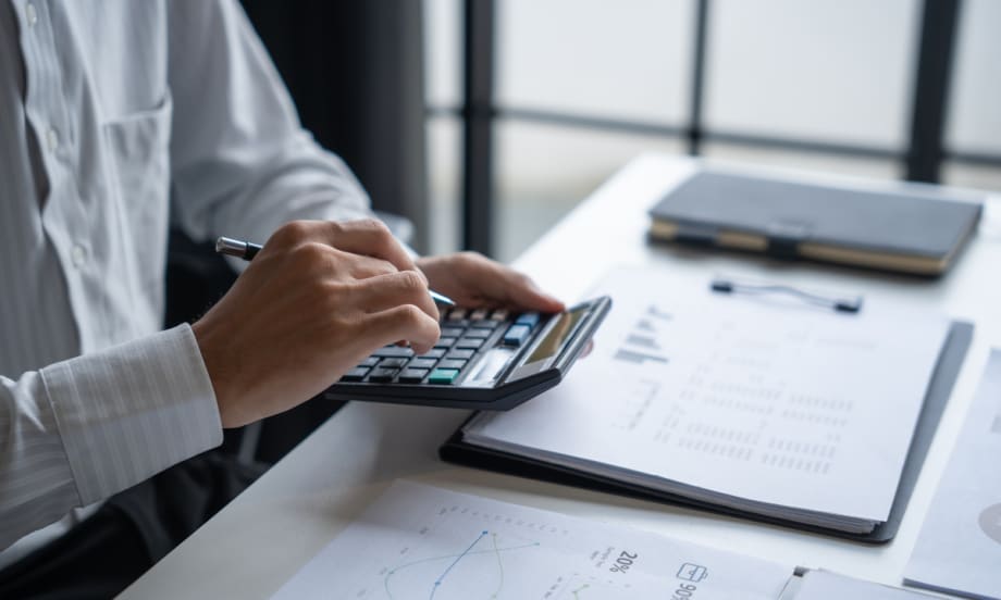 man sitting at desk using a calculator