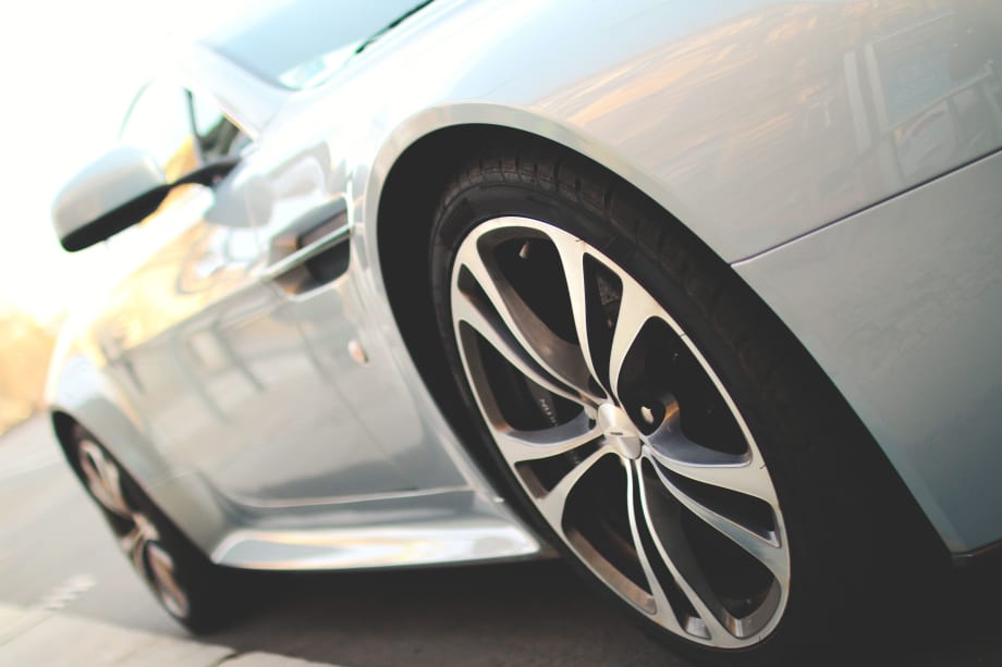 Closeup photo of a new white car on a road from the driver's side