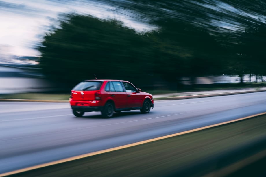 Blurred photo of red car moving down a road