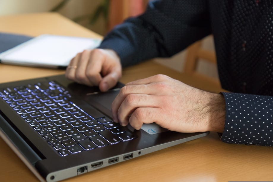 Photo of suited man's hands over a computer keyboard