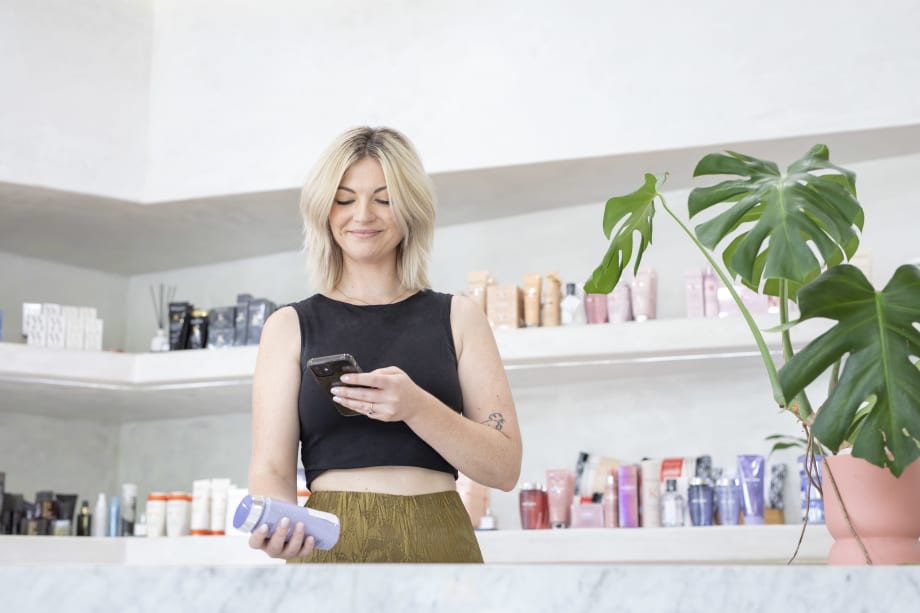 woman in salon scanning product with her phone