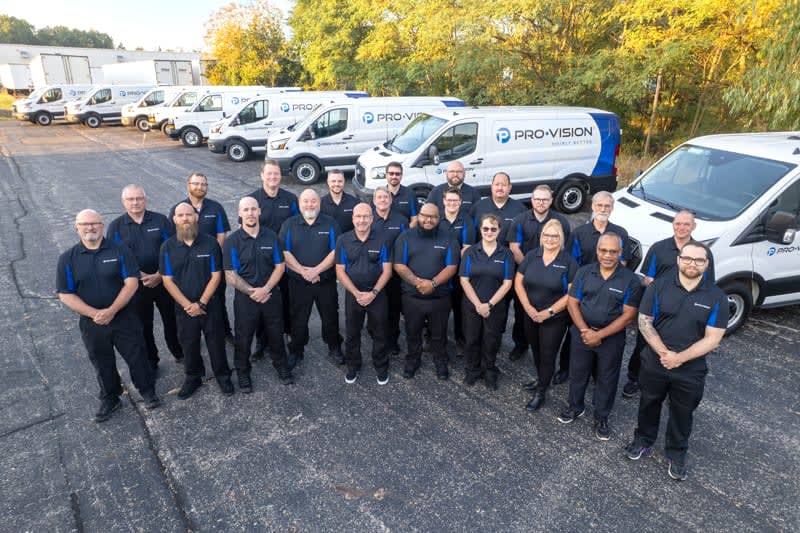 a line of pro-vision employees stand in front of branded company vans