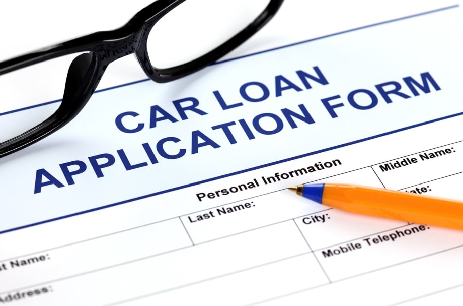 Image of a car loan application form with eyeglasses and a pencil sitting on top
