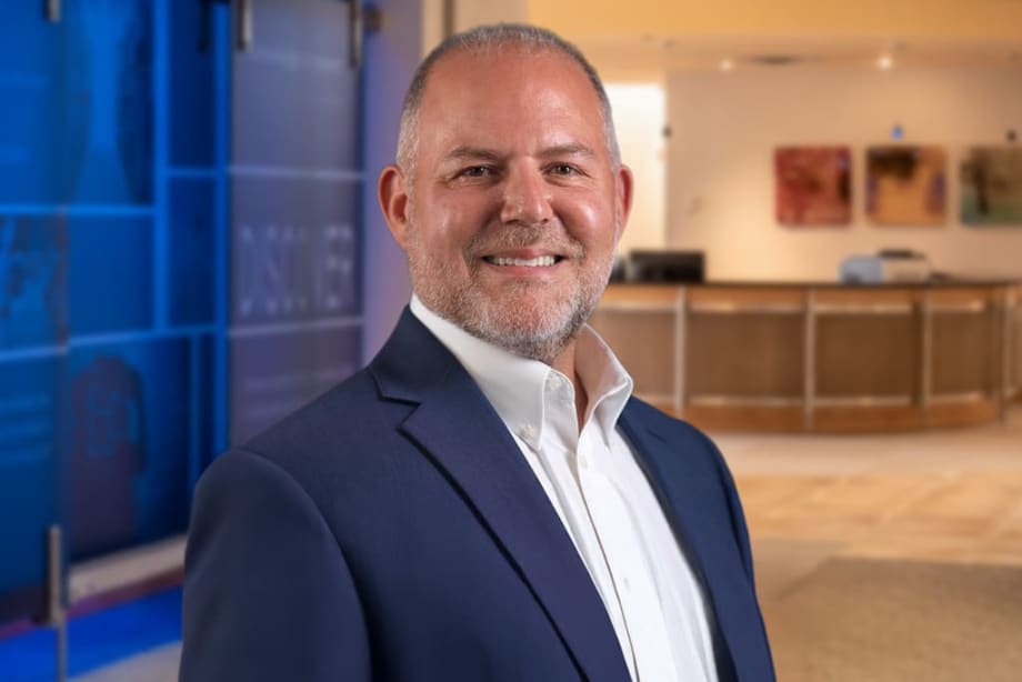 Man in blue suit smiling for photo.