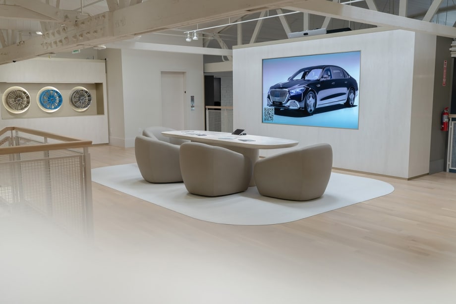 White meeting room in car dealership with rims displayed on wall and projected screen