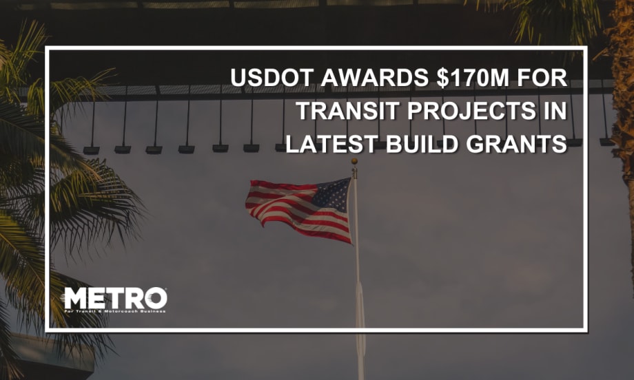 An image of an American flag waving under a bridge in Los Angeles with palm trees in the sunlight.