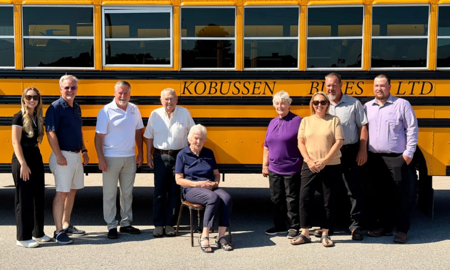 Multiple generations of the Kobussen family posing in front of a school bus.