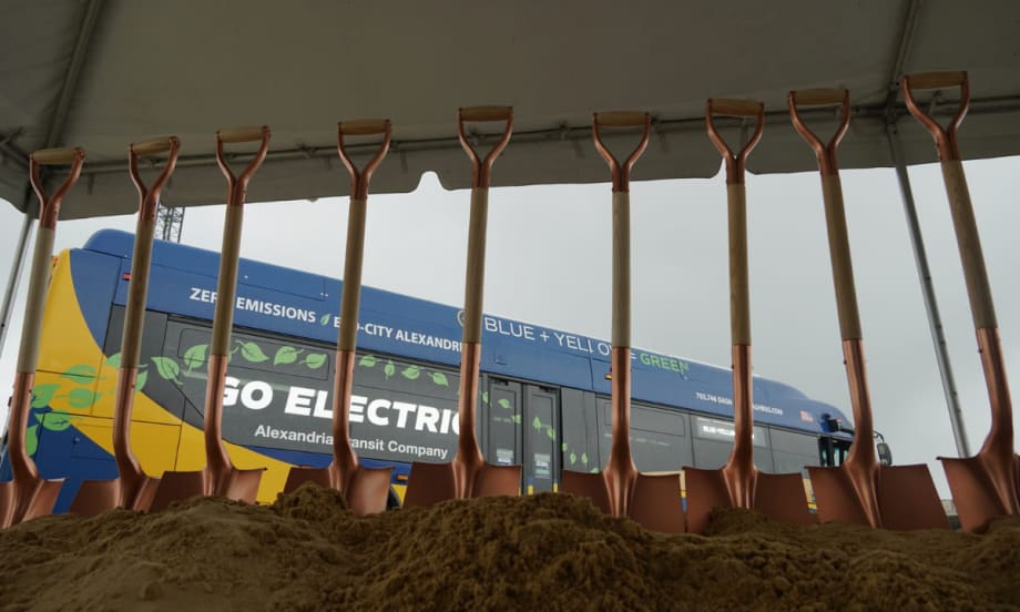 Shovels standing in dirt with a zero emissions bus in the background.