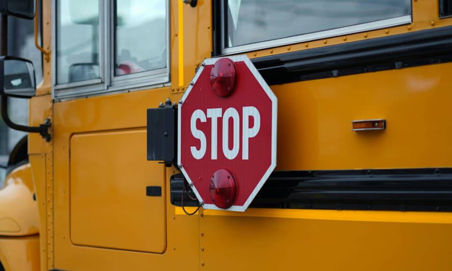 The side of a school bus with a retracted stop signal.