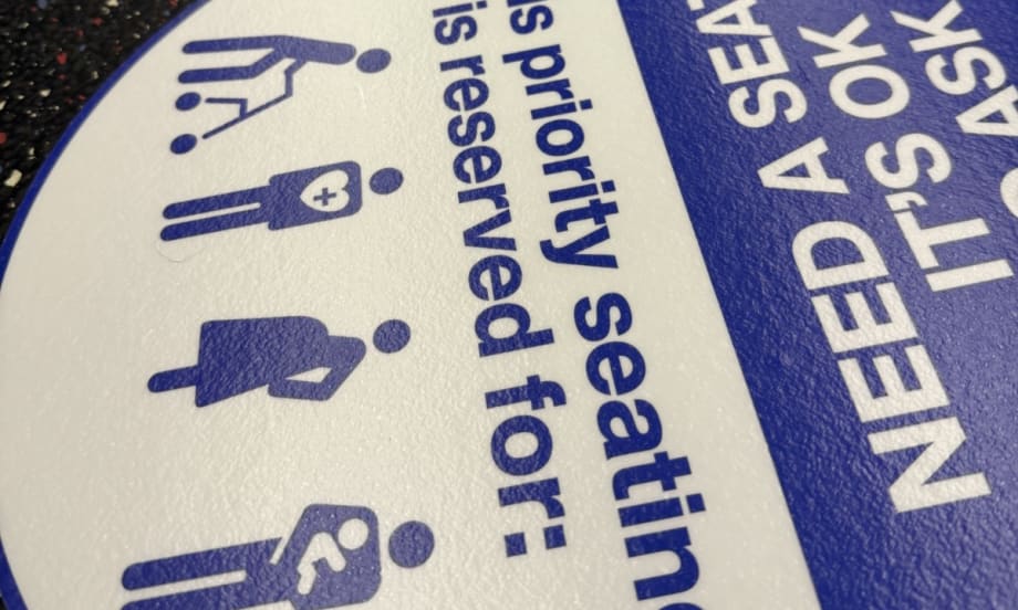 An up close image of WMATA priority seating sticker reminders.