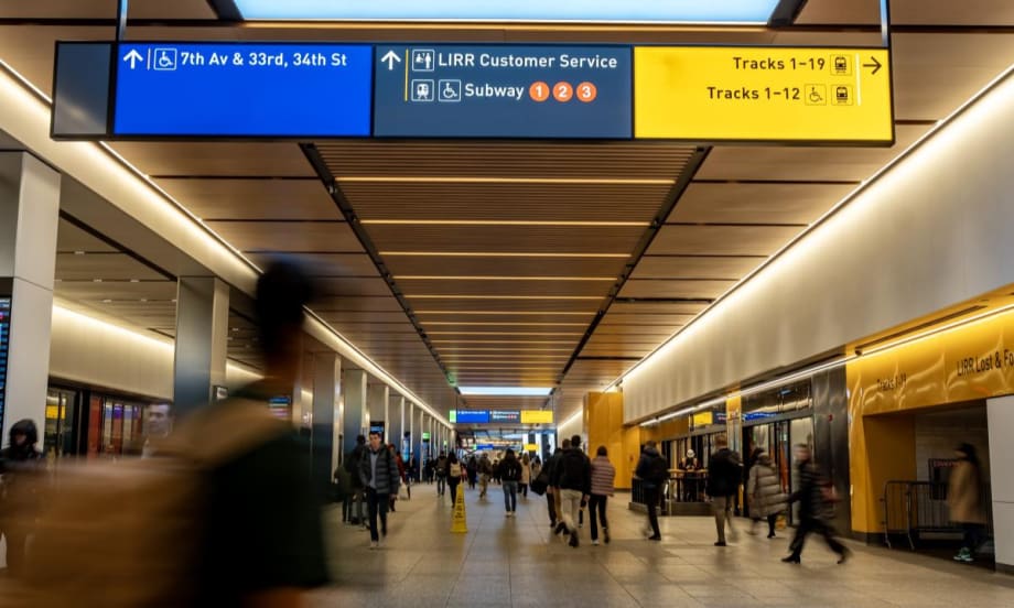 Image of Penn Station with people walking through the hallway.
