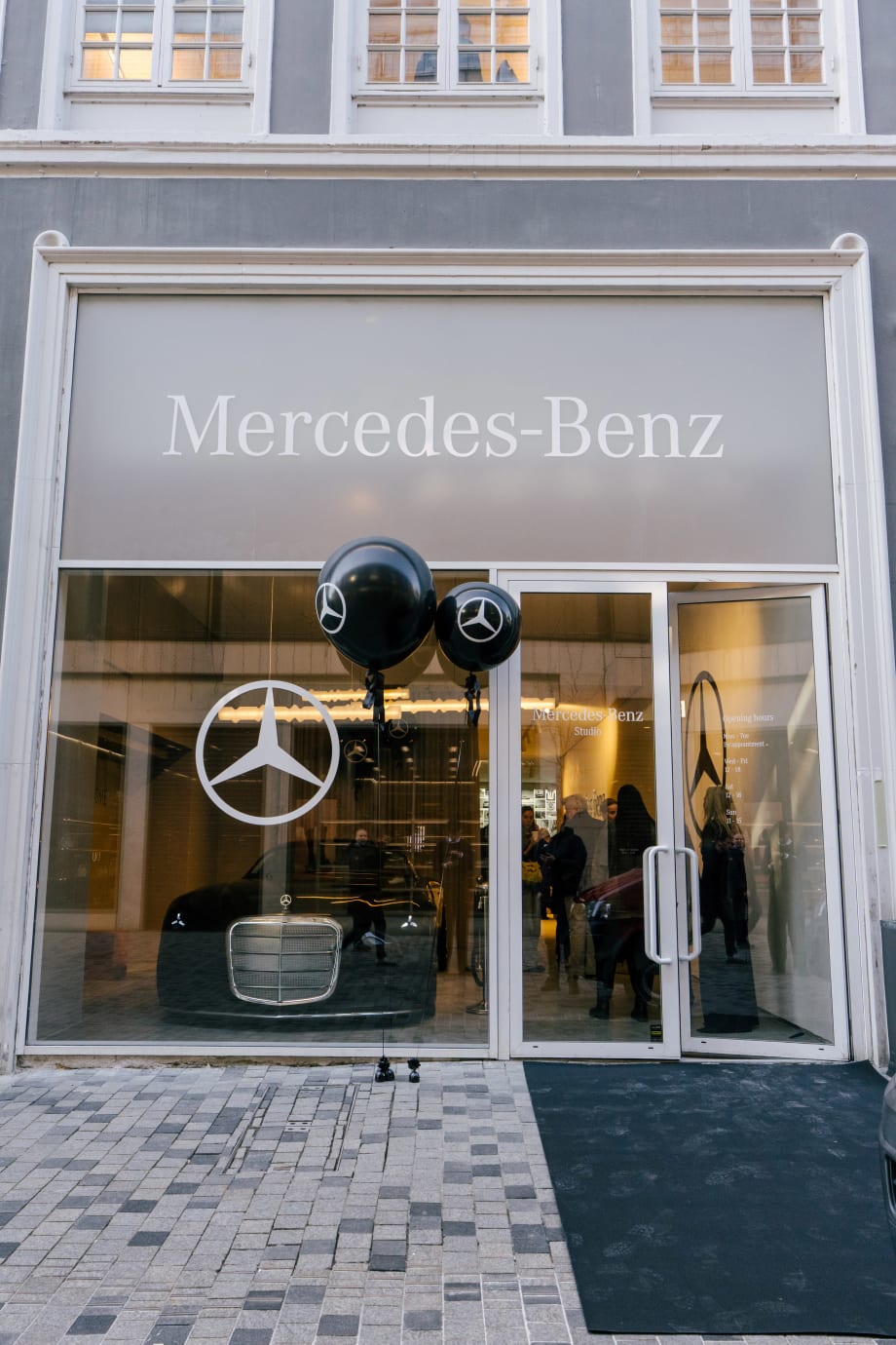 Photo of the facade of one of Mercedes' new city studios, with a vehicle displayed in the window