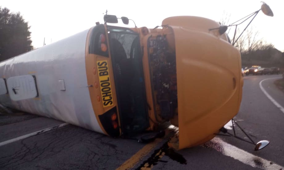 an overturned school bus on a roadway after an accident