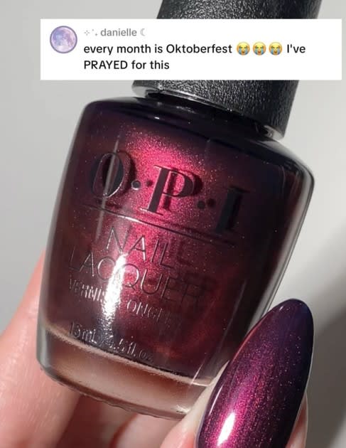 A bottle of nail polish being held by a hand.