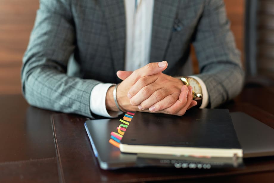 Photo of businessman's hands resting on files on a desk