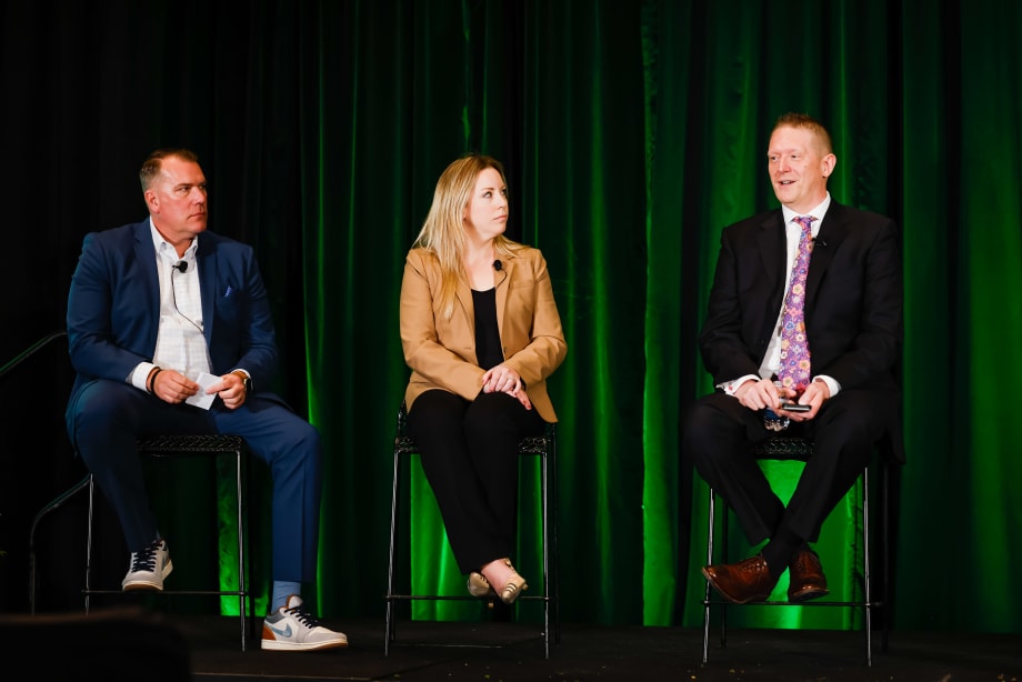 Two men and a woman on stage in discussion